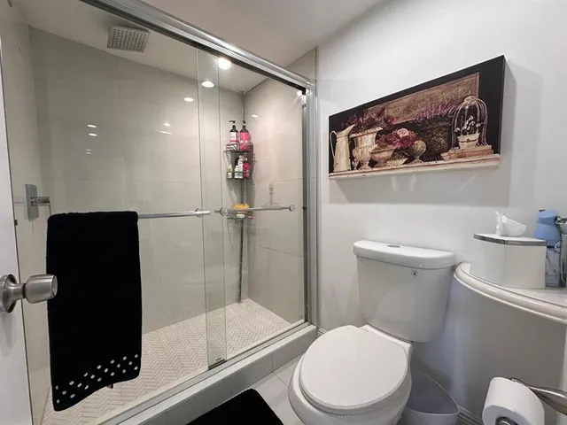 a white toilet sitting next to a bathroom sink and tub