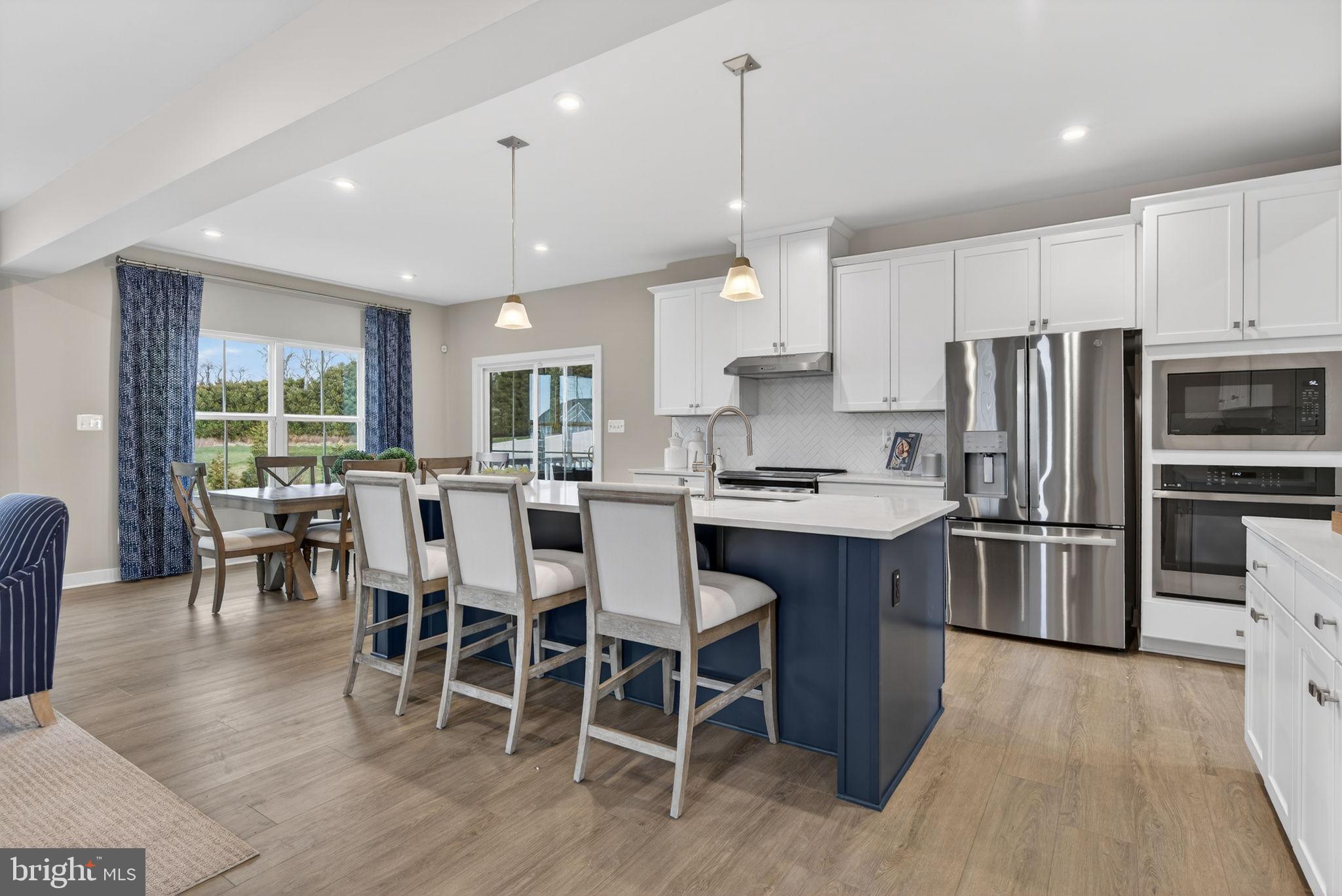 3575 Wildview Lane York, PA 17404 - Photo 8 of 62 a kitchen with stainless steel appliances a dining table chairs stove refrigerator and microwave