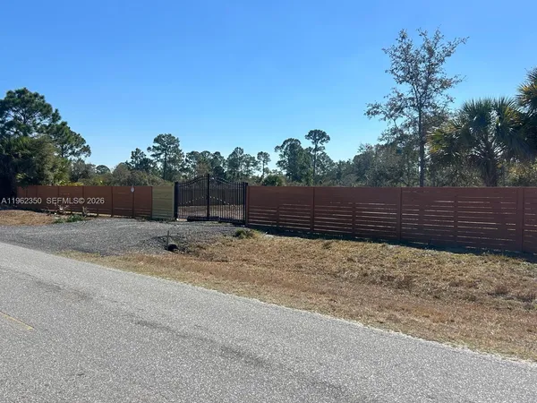 a view of wooden fence and trees