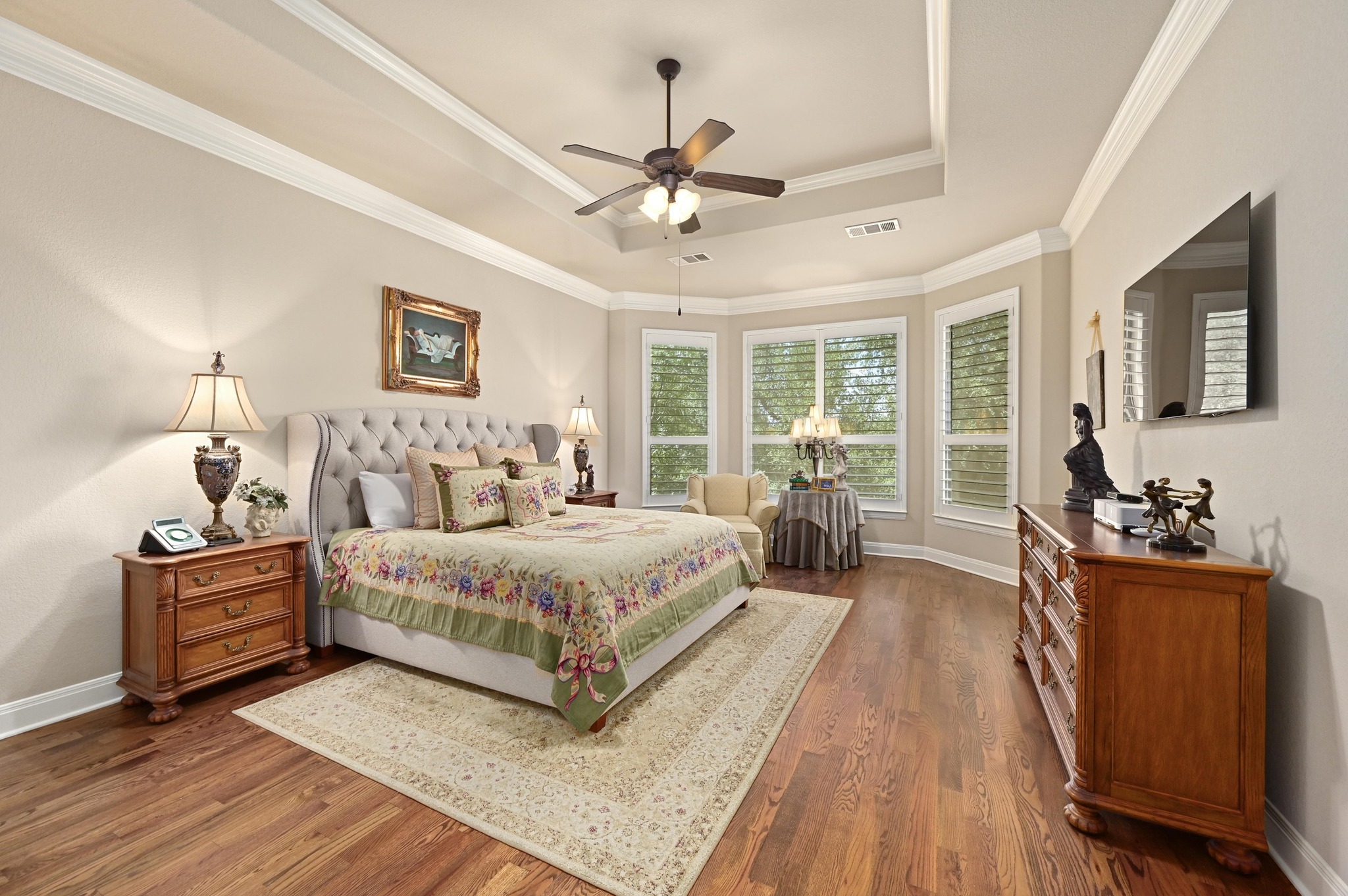 16129 Zagros Way Austin, TX 78738 - Photo 12 of 25 Primary Bedroom featuring a tray ceiling, wood floors and crown molding