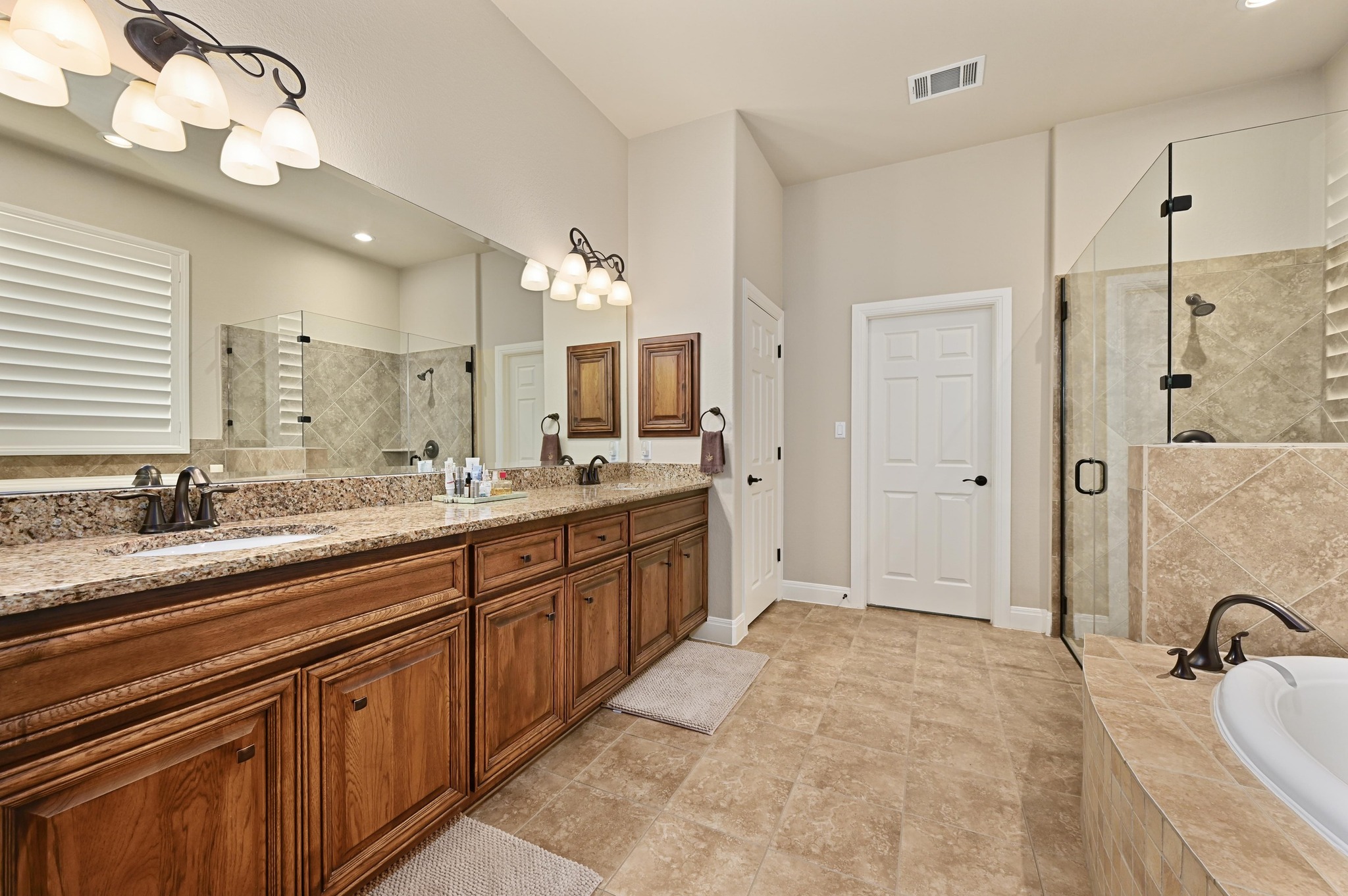 16129 Zagros Way Austin, TX 78738 - Photo 13 of 25 Primary Bathroom with double vanity, walk in closet and recessed lighting