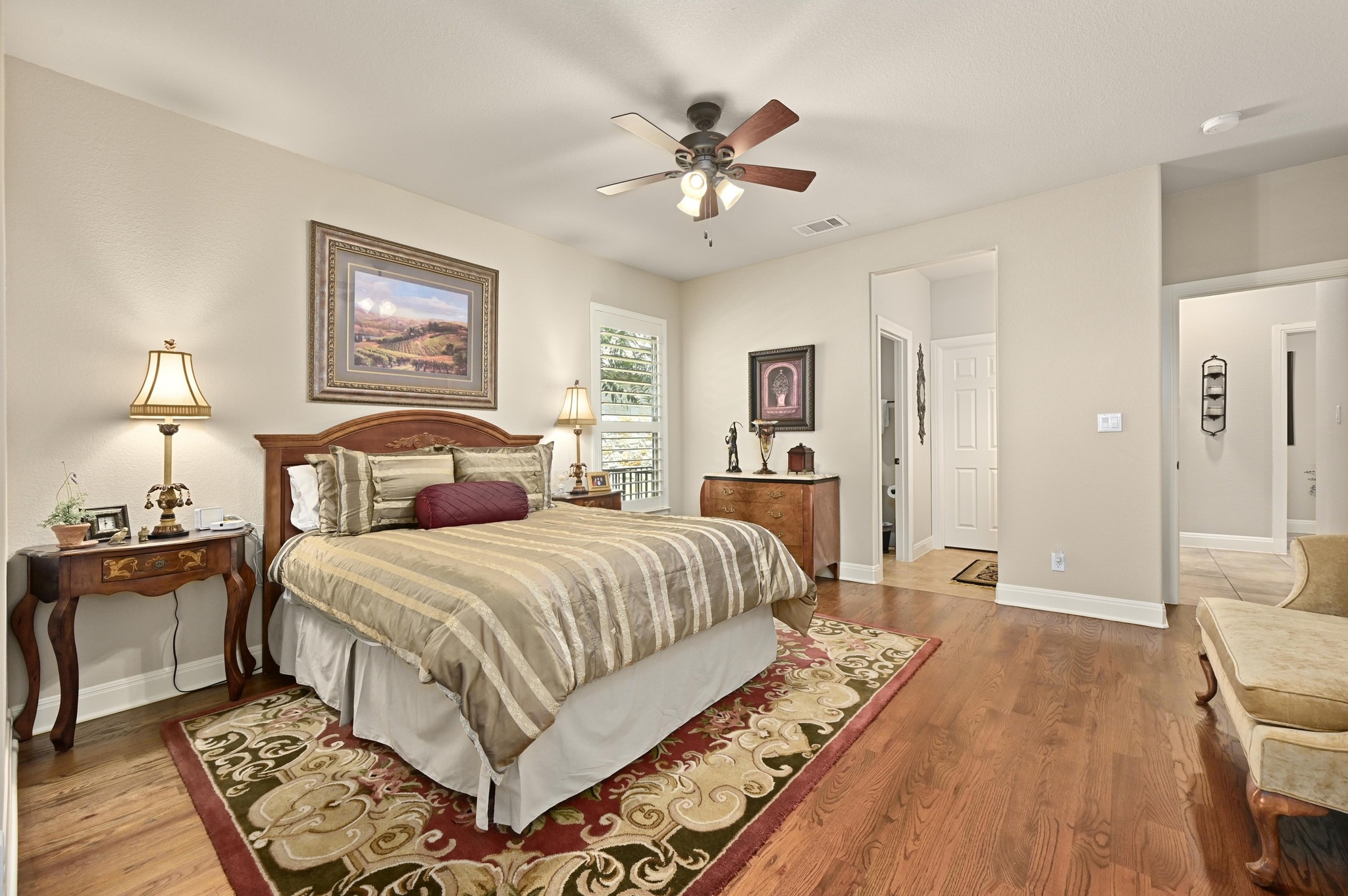 16129 Zagros Way Austin, TX 78738 - Photo 19 of 25 Bedroom featuring wood floors, ceiling fan, ensuite and walk in closet. Great In-Law plan