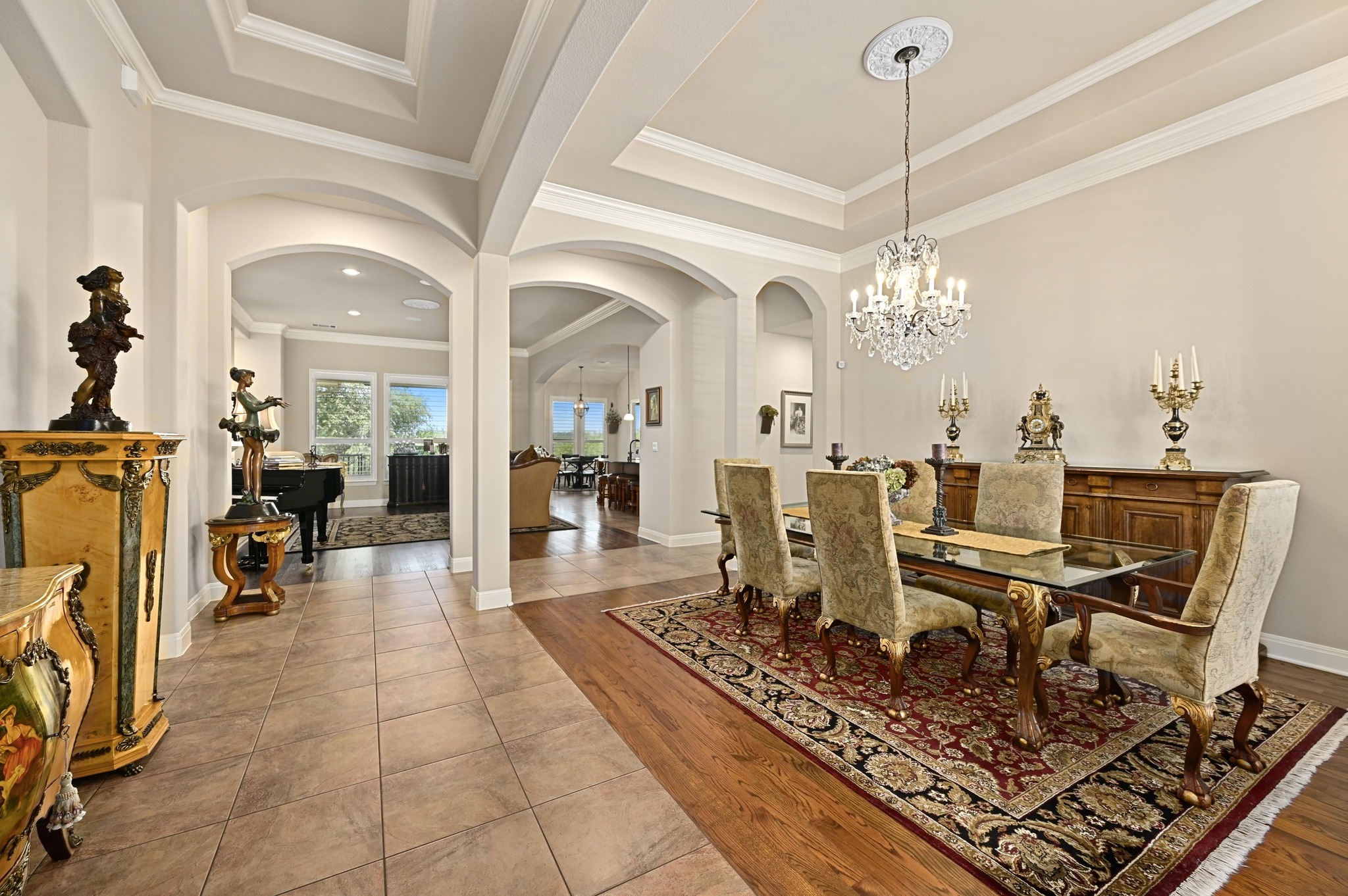 16129 Zagros Way Austin, TX 78738 - Photo 4 of 25 Dining room featuring arched walkways, wood floors, ornamental molding, and a tray ceiling