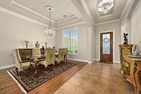 a living room with furniture a chandelier and a rug