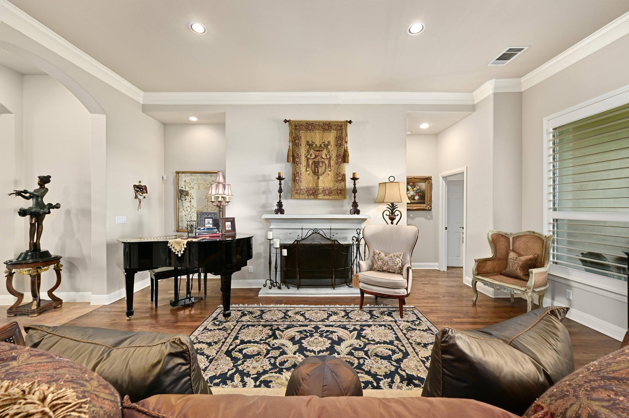 16129 Zagros Way Austin, TX 78738 - Photo 7 of 25 Living room featuring a fireplace with raised hearth, ornamental molding, wood floors, and recessed lighting