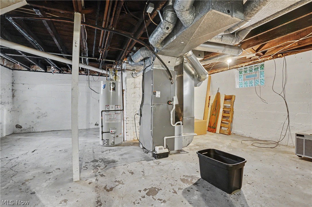 456 Delmar Avenue Akron, OH 44310 - Photo 26 of 27 Lower level utility space featuring exposed ceiling joists and ductwork, a water heater, and a furnace unit