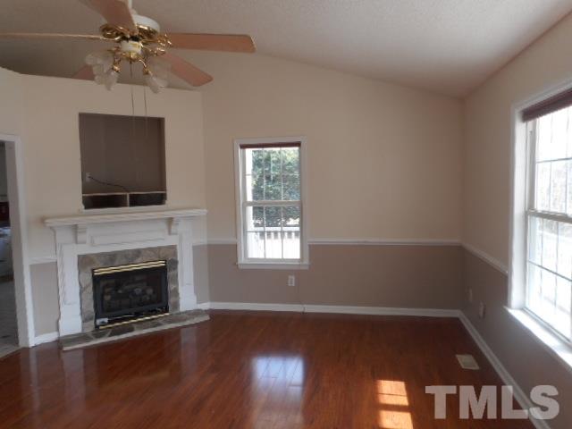 124 Forest Ridge Drive Willow Spring, NC 27592 - Photo 2 of 12 a view of an empty room with wooden floor fireplace and a window