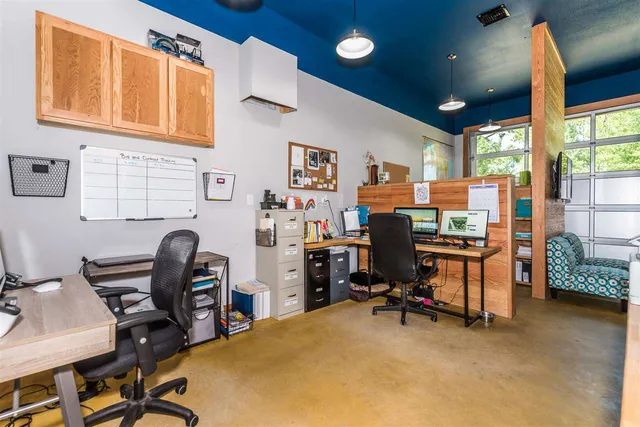 a view of a workspace with furniture and a window