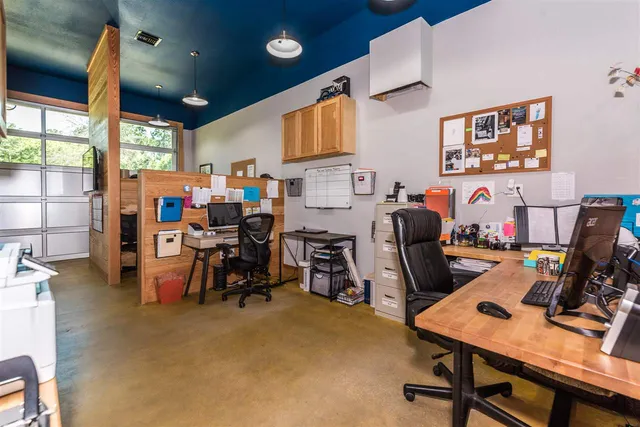 a view of a workspace with furniture and a window