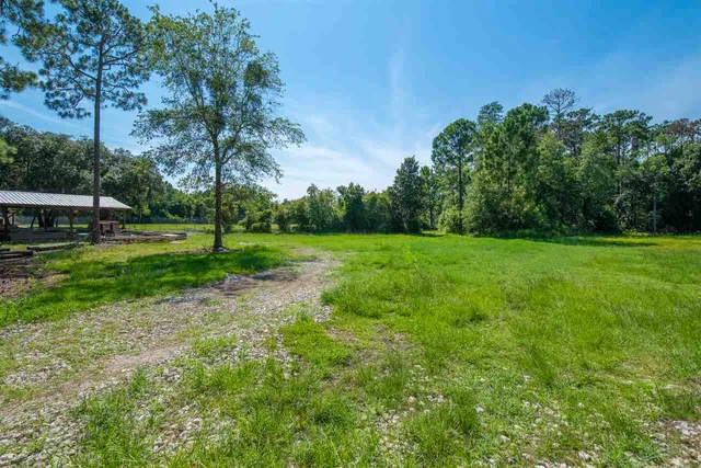 a view of a swimming pool with lawn chairs under an umbrella