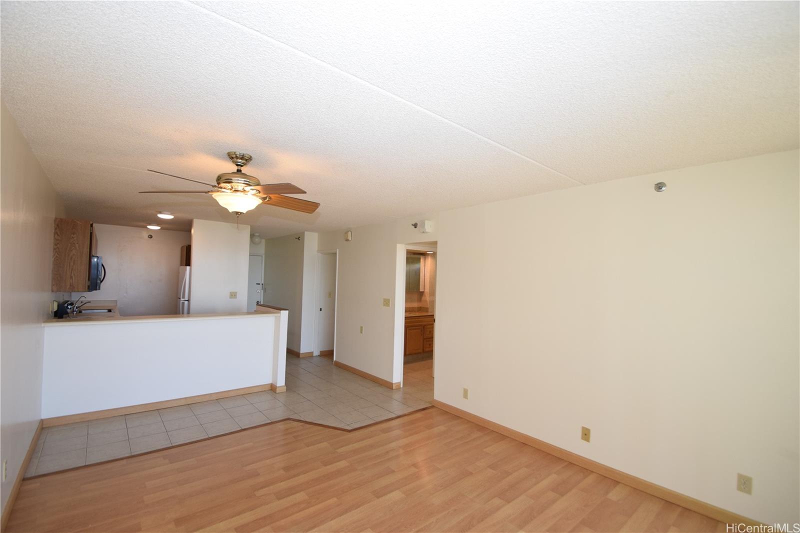 98-402 Koauka Loop, Unit 1916 Aiea, HI 96701 - Photo 4 of 24 an empty room with wooden floor and ceiling fan