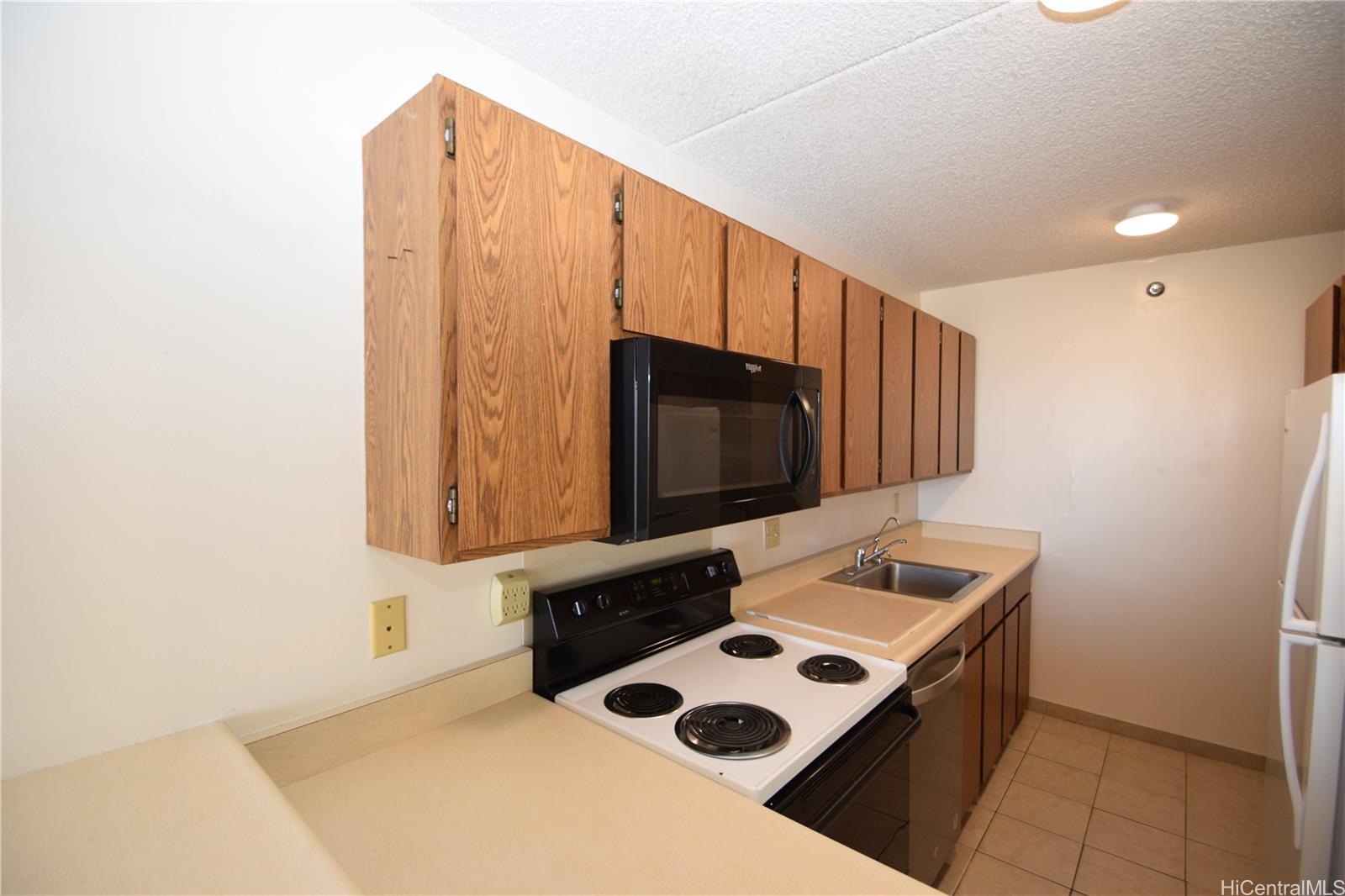 98-402 Koauka Loop, Unit 1916 Aiea, HI 96701 - Photo 5 of 24 a kitchen with a sink a microwave and cabinets