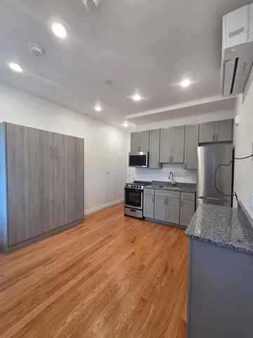 a large white kitchen with kitchen island a sink stainless steel appliances and cabinets
