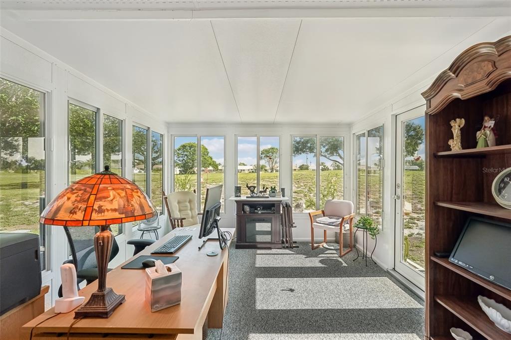708 Rutgers Place Sun City Center, FL 33573 - Photo 12 of 27 a living room with furniture a fireplace and a large window