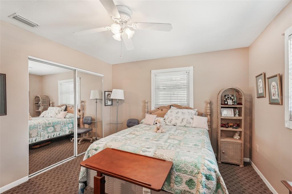 708 Rutgers Place Sun City Center, FL 33573 - Photo 21 of 27 a bedroom with a bed and a walk in closet