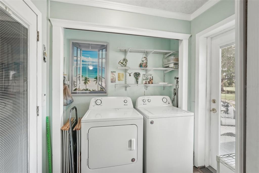 708 Rutgers Place Sun City Center, FL 33573 - Photo 22 of 27 a view of washer and dryer with bathroom in the background