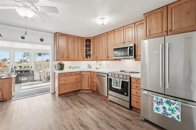 a kitchen with stainless steel appliances granite countertop a sink stove a refrigerator and cabinets