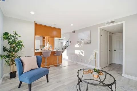 a living room with furniture a dining table a lamp and a potted plant