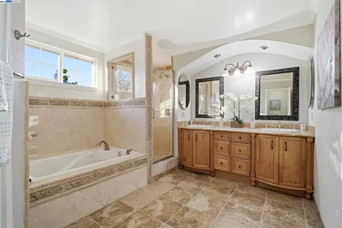 a spacious bathroom with a tub sink and mirror
