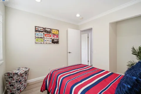 a bedroom with a bed and a painting on the wall