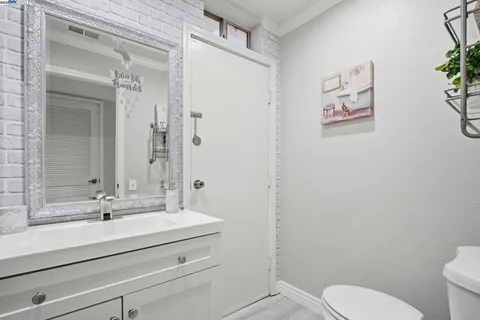 a bathroom with a sink mirror vanity and toilet