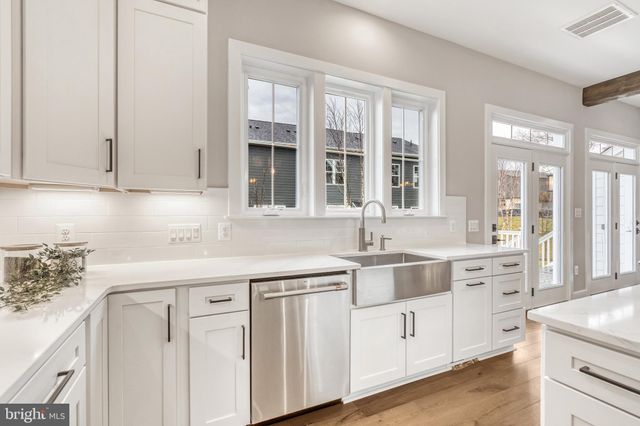 a view of a kitchen with white cabinets