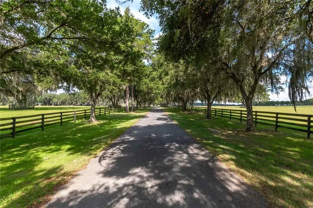 a view of a green field with wooden fence