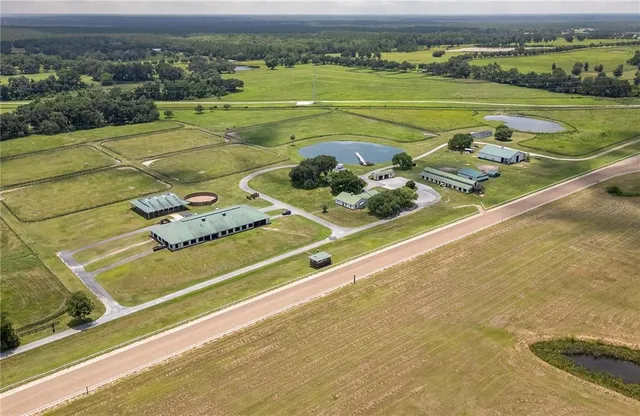 an aerial view of residential houses with outdoor space and trees