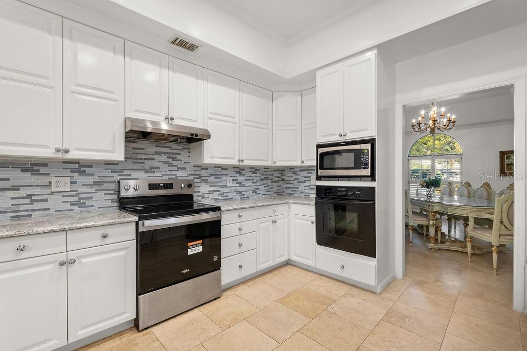 2958 Marquesas Court Windermere, FL 34786 - Photo 21 of 32 a kitchen with stainless steel appliances granite countertop a stove sink and cabinets