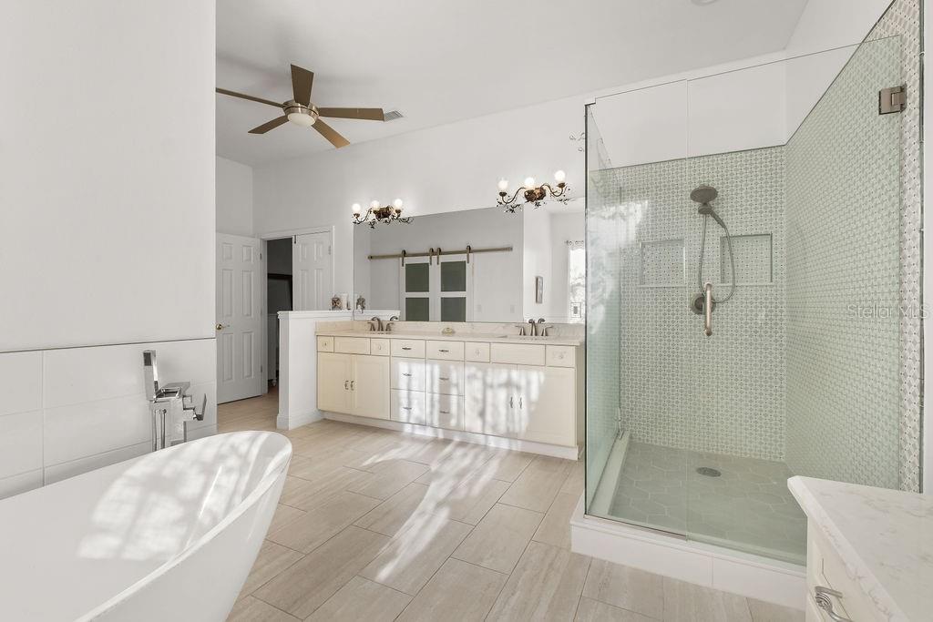 2958 Marquesas Court Windermere, FL 34786 - Photo 25 of 32 a bathroom with a tub sink mirror and shower