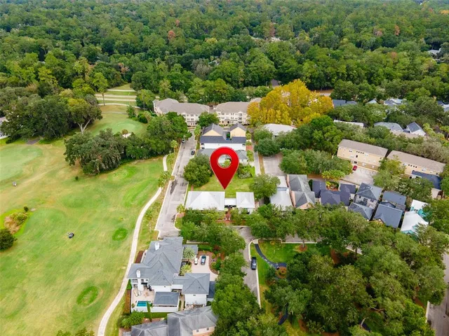 an aerial view of a house with a yard and outdoor seating