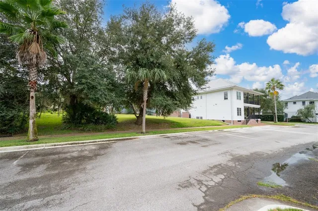 a view of a house with a yard and large trees