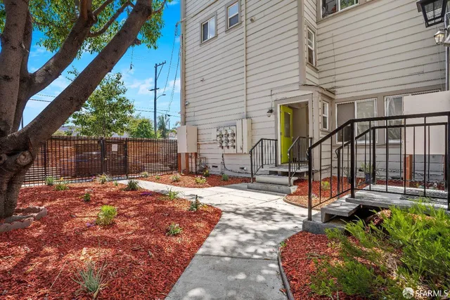 a view of a house with backyard and wooden fence