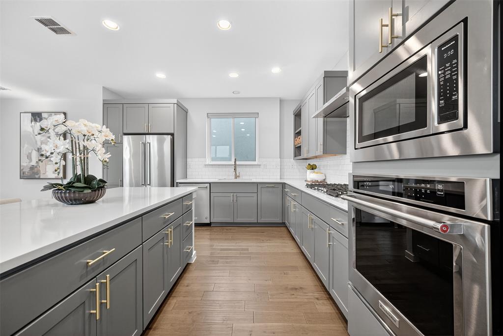 5333 Anita Street Dallas, TX 75206 - Photo 1 of 30 a kitchen with stainless steel appliances kitchen island granite countertop a stove a sink and a microwave