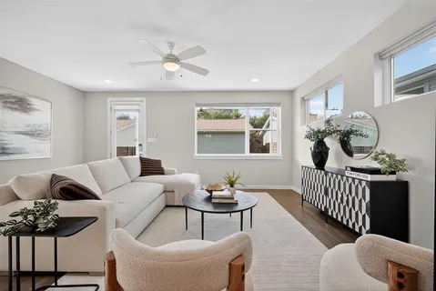 a view of a dining room and livingroom with furniture wooden floor a chandelier