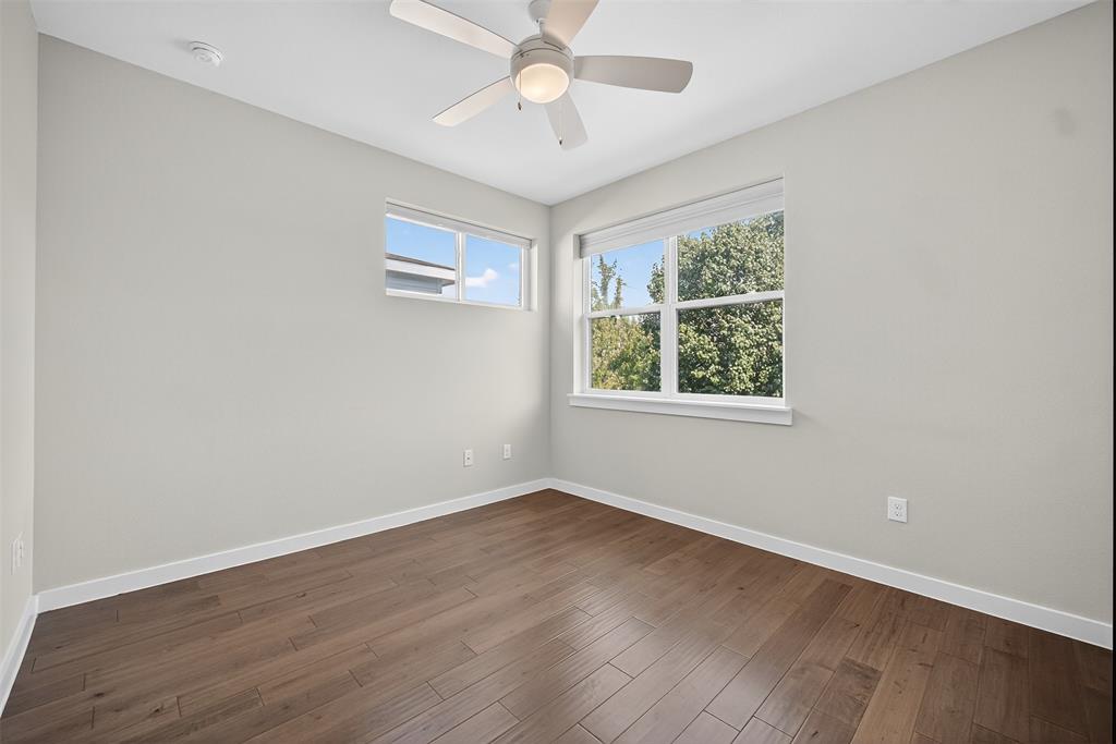 5333 Anita Street Dallas, TX 75206 - Photo 17 of 30 an empty room with wooden floor chandelier fan and windows