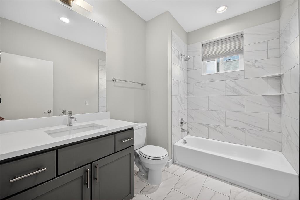 5333 Anita Street Dallas, TX 75206 - Photo 19 of 30 a bathroom with a sink a toilet and shower