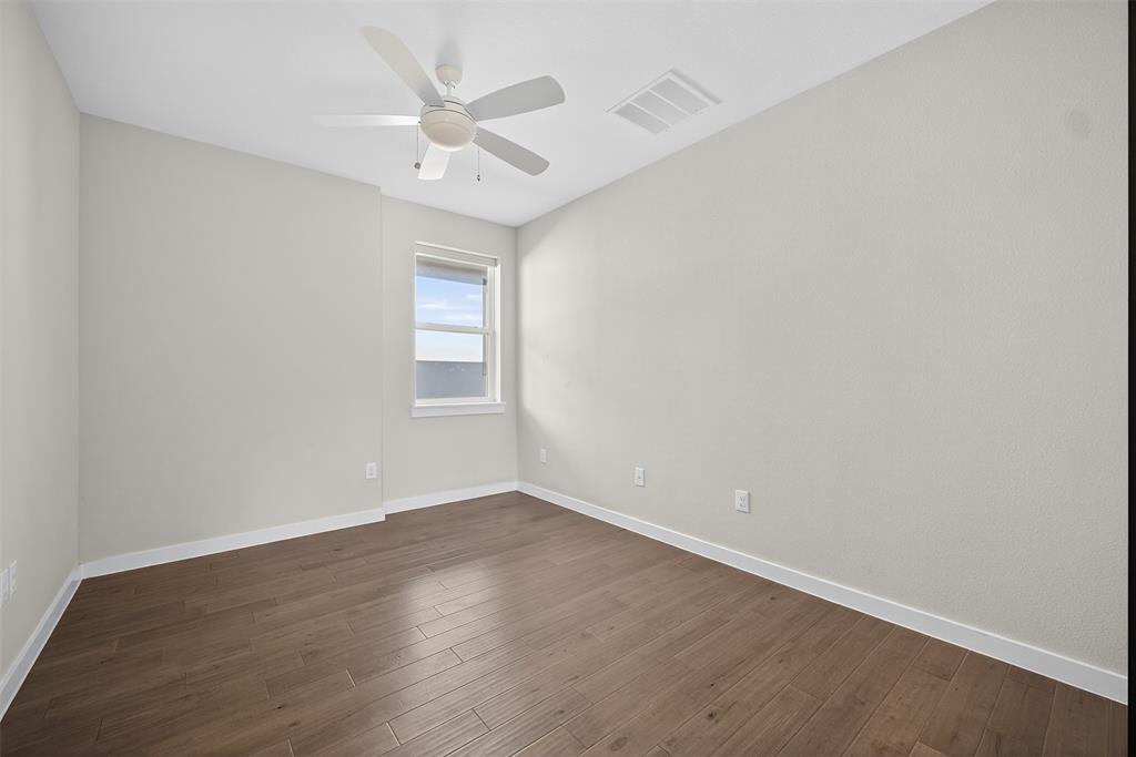 5333 Anita Street Dallas, TX 75206 - Photo 20 of 30 an empty room with wooden floor fan and windows