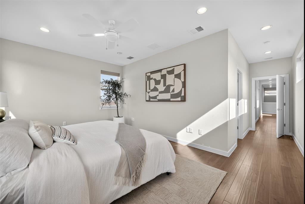 5333 Anita Street Dallas, TX 75206 - Photo 24 of 30 a bedroom with a large bed and a wooden floor