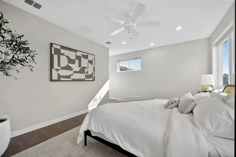 a bedroom with a large bed and a wooden floor