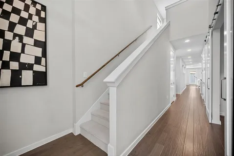 a view of a hallway with wooden floor and staircase