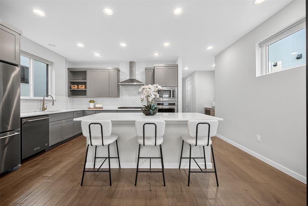 5333 Anita Street Dallas, TX 75206 - Photo 7 of 30 a kitchen with stainless steel appliances a dining table chairs microwave and sink