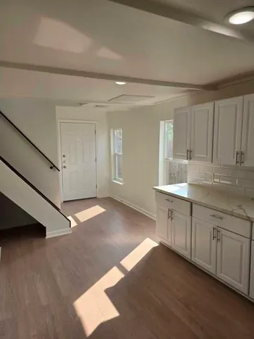 a view of a kitchen with wooden floor and electronic appliances