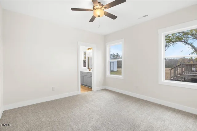 a view of empty room with window and ceiling fan