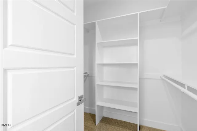 a view of walk in closet with empty racks