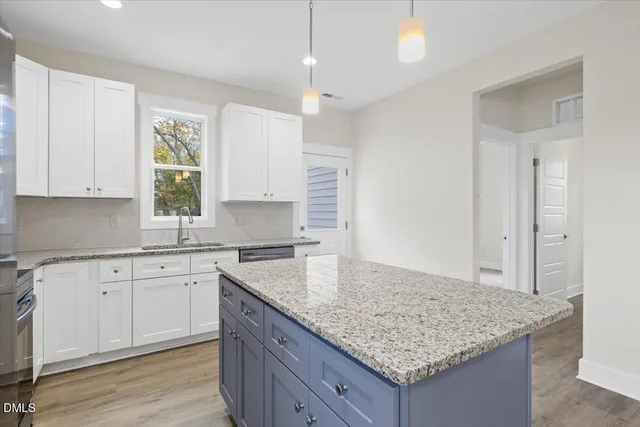 a kitchen with granite countertop kitchen island sink and cabinets