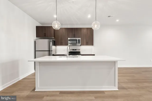 a kitchen with kitchen island a sink and a stove