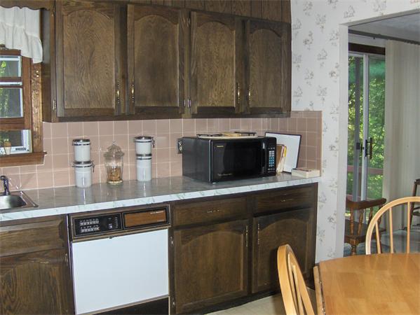 1754 Shirley Road Lancaster, MA 01523 - Photo 14 of 30 a kitchen with granite countertop a stove a microwave a sink and cabinets