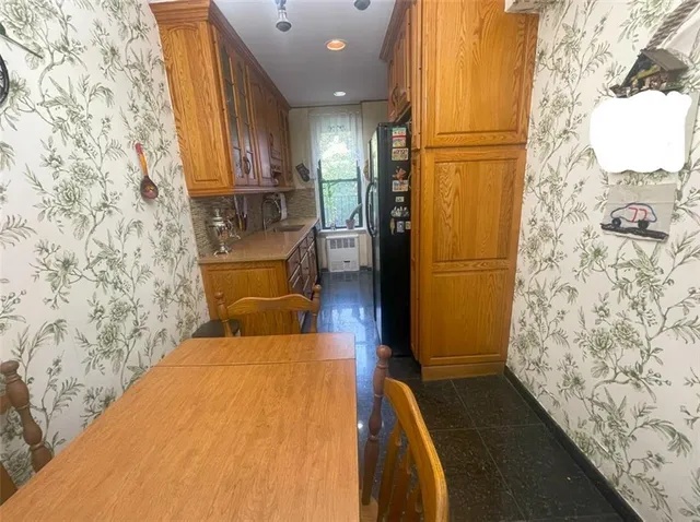 a kitchen with stainless steel appliances kitchen island granite countertop a sink and a refrigerator