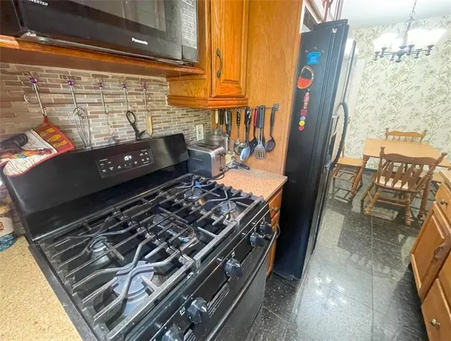 a kitchen with stainless steel appliances granite countertop a refrigerator a stove and a sink